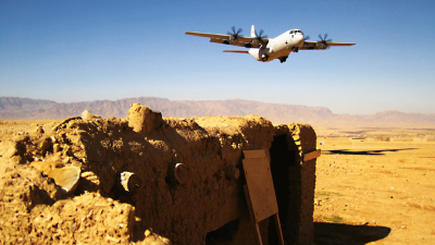 A plane flying above a desert.
